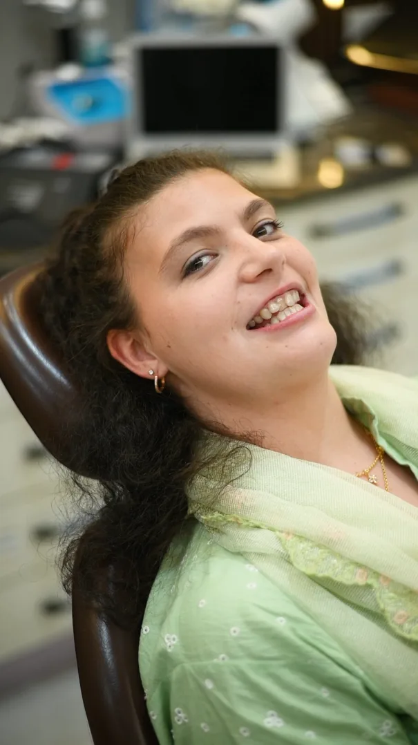 Smiling young woman reclining in a dental chair at Smile Mender, Gujranwala