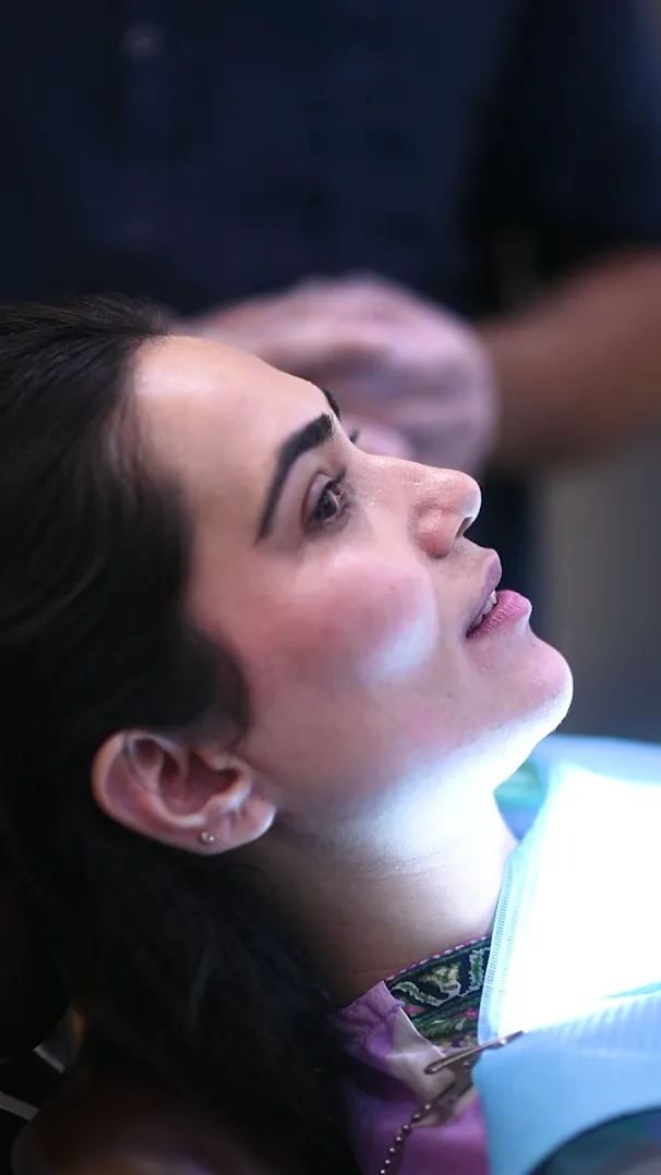 Woman relaxing in a dental chair under the treatment light